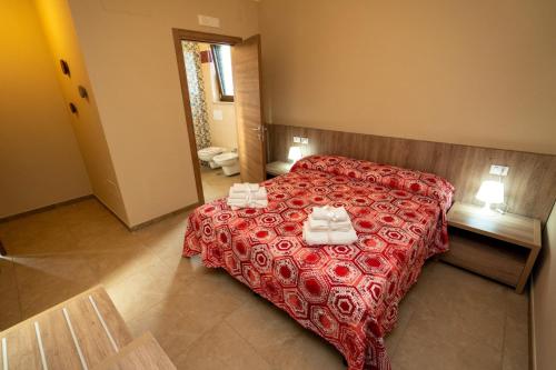 Montesano sulla MarcellanaIl Tufo的一间卧室配有红色的床和毛巾
