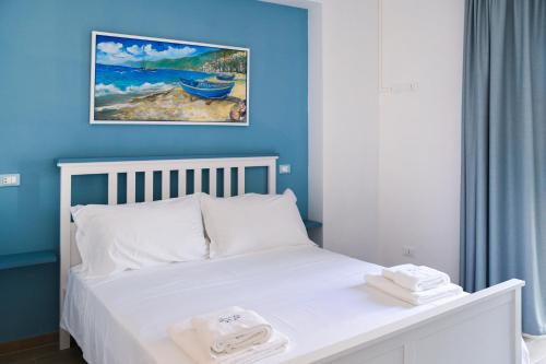 希拉Signora Tita B&B Chianalea - Scilla的卧室配有白色床和蓝色墙壁