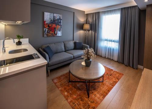 伊斯坦布尔Valente Suites&Hotel的客厅配有沙发和桌子