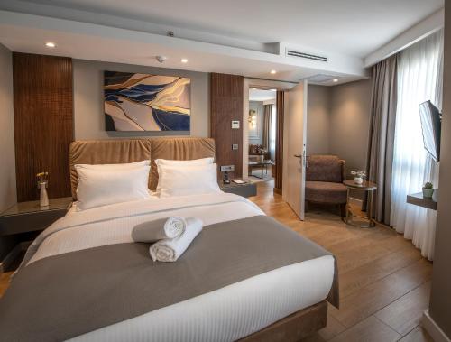 伊斯坦布尔Valente Suites&Hotel的一间卧室配有一张大床和毛巾