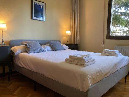 纳瓦塞拉达Gran chalet con piscina y apartamento en Navacerrada的一间卧室配有一张大床和毛巾