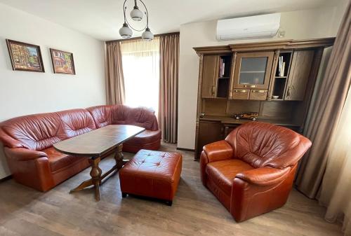 哈斯科沃RELAX Apartments in HASKOVO, Apt1的客厅配有皮革家具和桌椅