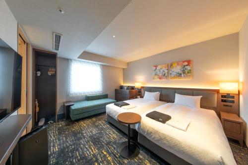 名古屋Hotel Forza Nagoya Sakae的酒店客房设有一张大床和一台电视。