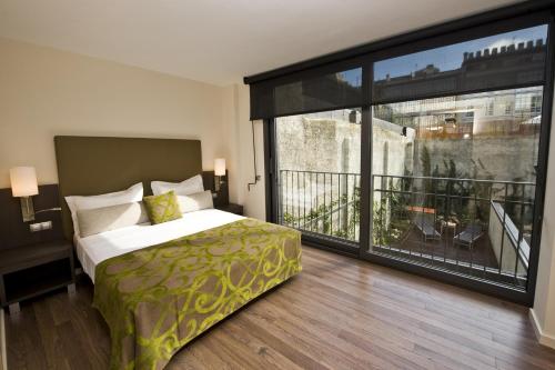 巴塞罗那卡斯普74公寓式酒店的一间卧室设有一张床和一个大窗户