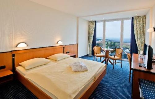 格拉斯许特全景酒店的酒店客房带一张床、一张桌子和椅子