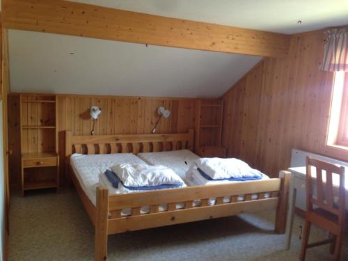 奥萨Hansjö Stugby - Mickolavägen的一间卧室配有一张带木墙的大床