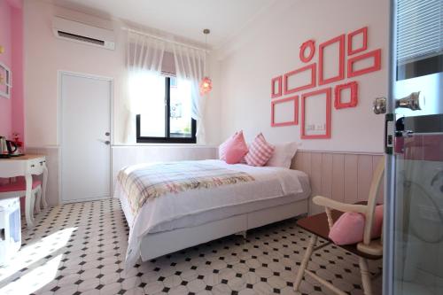 花莲市依九九九民宿的一间卧室配有一张粉红色的墙壁和窗户。