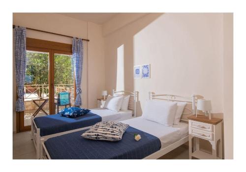 利加里亚Beachfront Blue apt-Ligaria beach的带窗户的客房内的两张床