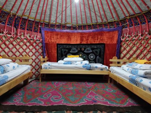 卡拉科尔Karakol Yurt Lodge & Homestay的蒙古包内带两张床的房间