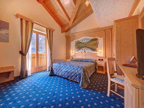 佛加里达Hotel Madonna delle Nevi的一间卧室配有一张蓝色地毯的床