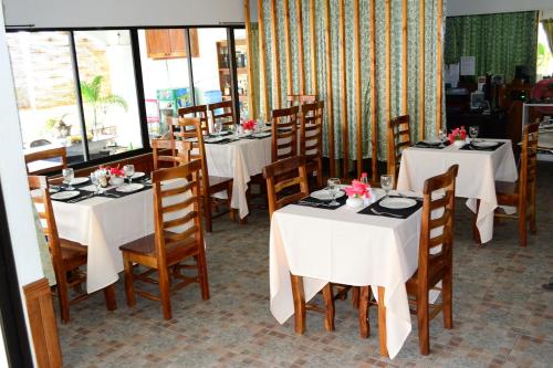 桑坦德亚当度假酒店的一间设有白色桌椅的用餐室
