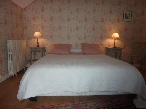 LuzechL'orée du bois的一间卧室配有一张带两盏灯的大型白色床。