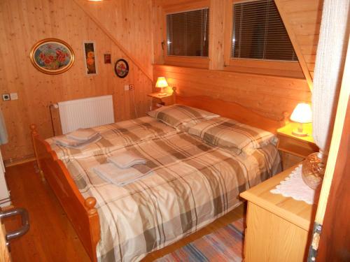 克拉尼斯卡戈拉Holiday Home Gobela的木制客房内的一间卧室,配有一张床