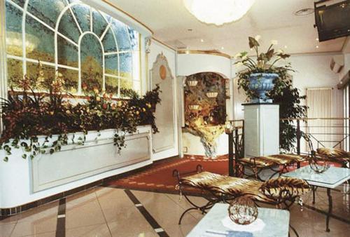 Cittiglio拉布索拉酒店的一间设有大窗户的客房,墙上挂着植物