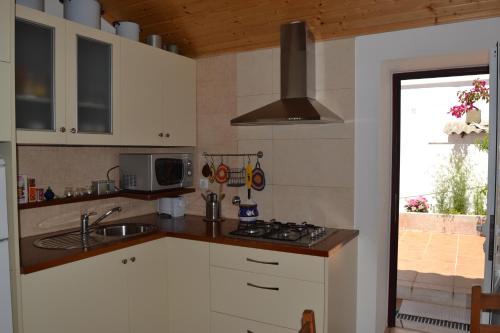 圣特奥托纽Casa Alentejana的厨房配有水槽和炉灶 顶部烤箱