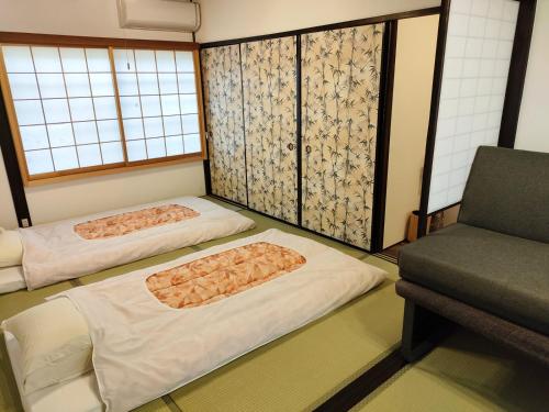 京都Kyoto Villa Fuka的配有椅子的客房内的两张床