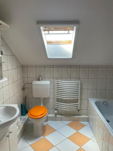 豪伊杜索博斯洛Julius Apartman的浴室设有卫生间和橙色盖子