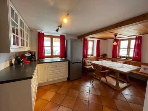 哈尔布莱希Bergien的一间带桌子的厨房和一间带红色窗帘的厨房