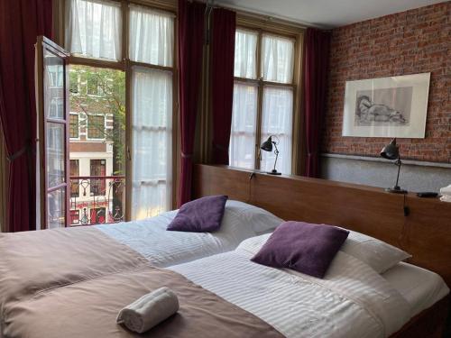 阿姆斯特丹Hotel & bar Royal taste Amsterdam的一间卧室设有两张床和窗户。