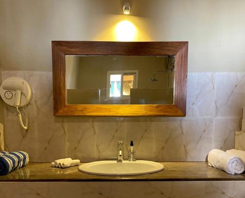 帕杰Paje Beach Apartments & Hotel的一间带水槽和镜子的浴室