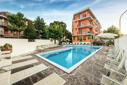 圣贝内代托-德尔特龙托菲尼克斯酒店的一座带椅子的游泳池以及一座建筑