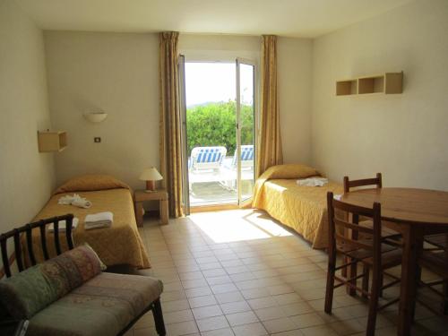 卡尔维圣弗朗索瓦汽车旅馆的酒店客房设有两张床、一张桌子和一个庭院。