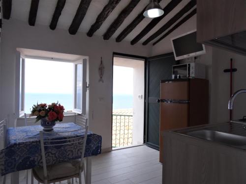 Isola del Giglioalcastello - Casamatta via Dante Alighieri,36的厨房配有桌子,享有海景