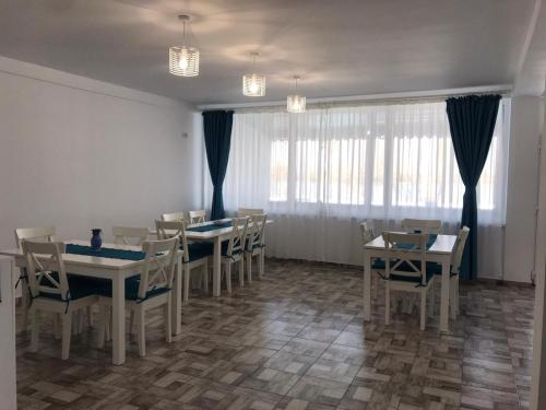 CreţeştiPensiunea Rares的用餐室设有桌椅和窗户。