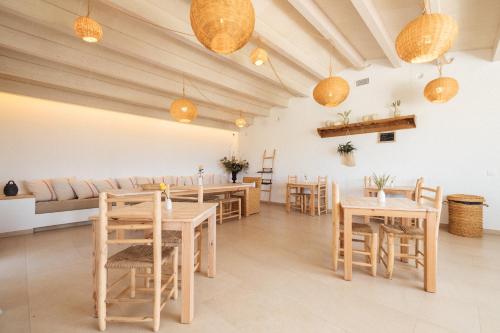 休达德亚Agroturismo Ses Talaies的餐厅设有木桌、椅子和沙发。
