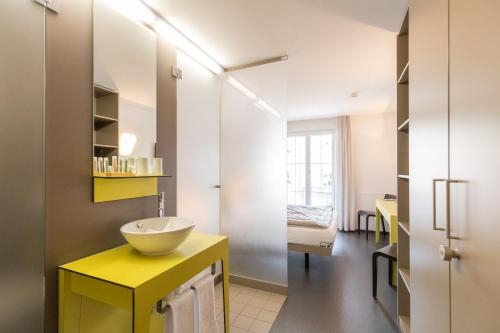 GelfingenHotel Restaurant Sternen的浴室设有黄色水槽和镜子