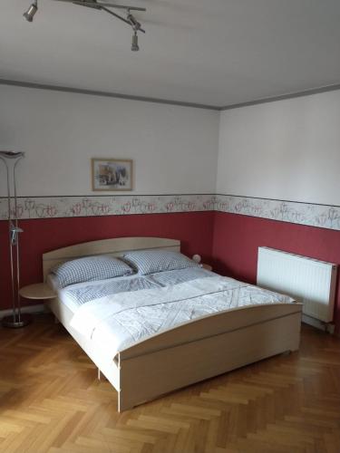 盖布利茨Ferienwohnung Madlene 2的一间卧室配有一张红色和白色墙壁的床