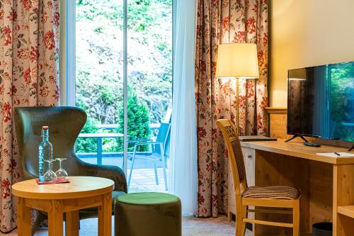 茨维泽尔Robenstein Aktivhotel & SPA的酒店客房设有一张桌子、一台电视和一张桌子
