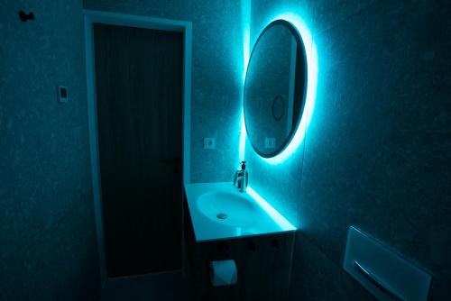 博维茨Emerald Valley Apartments的一间带水槽和蓝光镜子的浴室