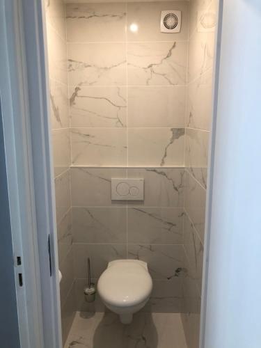 尼斯盎格鲁大道29号公寓的浴室铺有大理石瓷砖,设有白色卫生间。