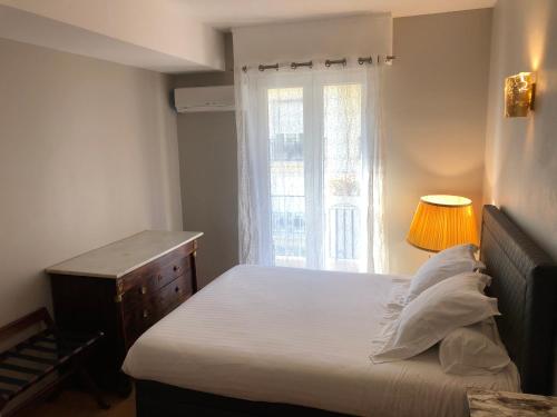 尼斯盎格鲁大道29号公寓的一间小卧室,配有床和窗户