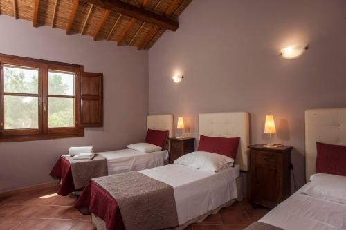 特乌拉达Casa vacanza Asfodeli的一间卧室设有两张床和窗户。