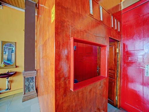 棉兰OYO 90387 Sepakat Guest House的一间带红色墙壁和红色门的浴室