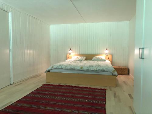 希勒勒Villa 4 rooms的一间卧室配有一张带两盏灯和地毯的床。