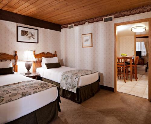 班夫查尔顿班夫旅馆的酒店客房设有两张床和一张桌子。