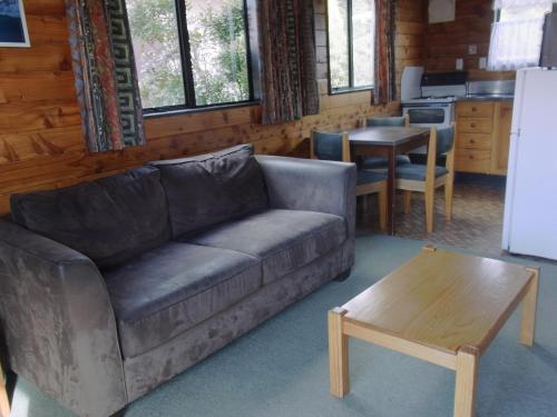 奥阿库尼奥斯小屋汽车旅馆的客厅配有沙发和桌子