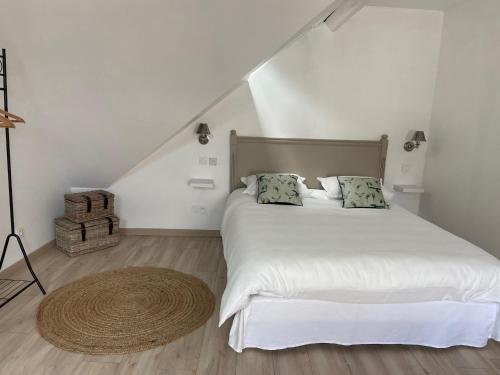 博讷Au coin des Hospices的卧室配有白色的床,铺有木地板