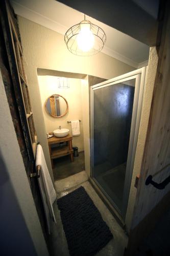 波罗瓜尼SOUSIE'S RUSTIC STAY的一间带步入式淋浴间和镜子的浴室