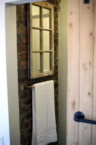 波罗瓜尼SOUSIE'S RUSTIC STAY的一间带窗户和毛巾的浴室