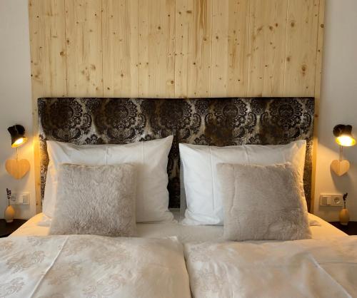 拉伊翁Alpine Chalet Aurora Dolomites的卧室配有带白色枕头的大床