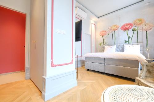 蒙斯La Maison de la Duchesse de la Vallière - Chambre Rosaline - Parking privé gratuit的卧室配有一张床,墙上挂着鲜花