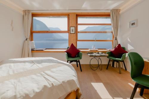 哈尔施塔特Polreich Bed&Breakfast的一间卧室配有一张床、两把椅子和一张书桌
