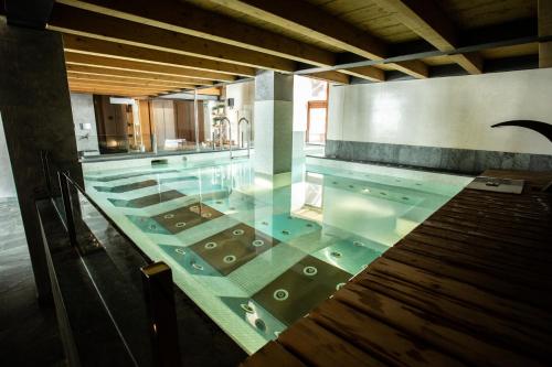 布勒伊-切尔维尼亚塞尔托雷利运动酒店的一座带玻璃地板的大型游泳池