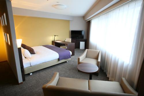 宇都宫宇都宫大和鲁酒店的配有一张床和一把椅子的酒店客房