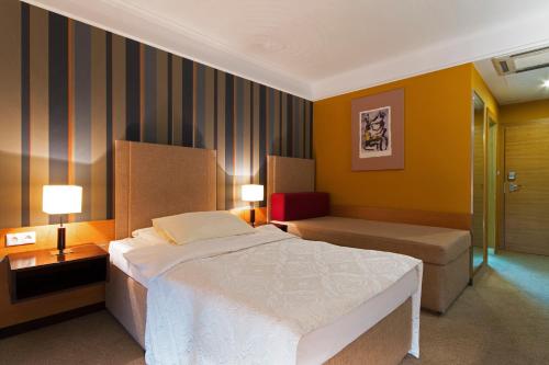 特尔纳瓦伊恩帕库酒店的一间卧室配有一张床、两张桌子和两盏灯。