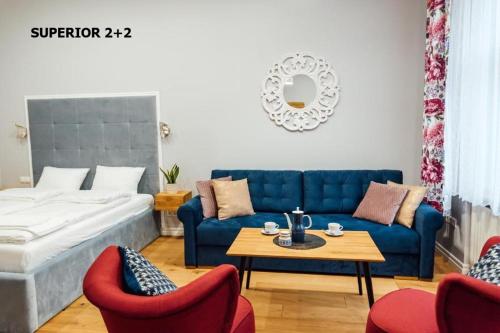 别尔斯克-比亚拉Apartamenty Centrum - Mickiewicza的客厅配有蓝色的沙发和红色的椅子
